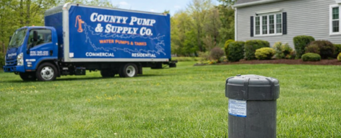 County Pump & Supply truck near a residential well head in a Massachusetts yard during spring well system maintenance